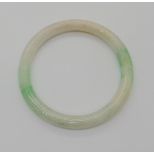 761 - A CHINESE GREEN HARDSTONE BANGLEmainly white with green details, inner diameter 6cm, thickness 0.9cm... 