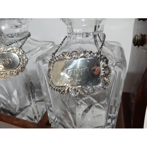 254 - A PB & S three bottle decanter tantalus with four silver spirit labels