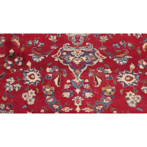 132 - A RED GROUND KESHAN RUGwith blue central medallion, matching spandrels and borders, signature to one... 