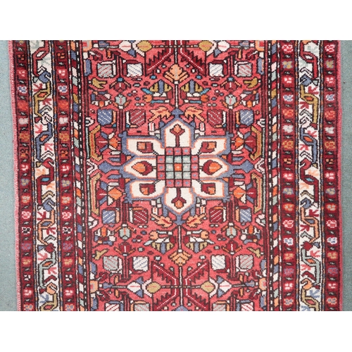 133 - A RED GROUND IRANIAN HAMEDAN RUNNERwith all over design and multiple borders, 339cm long x 108cm wid... 