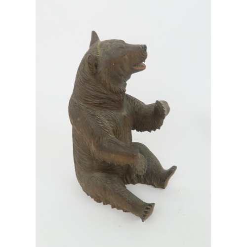 213 - A BRONZE SCULPTURE OF A LION22cm long together with a Black Forest Sculpture of a bear (2)... 