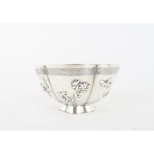 306 - A CHINESE SILVER LOBED BOWLcast with panels of birds, butterflies and foliage, within key pattern ba... 