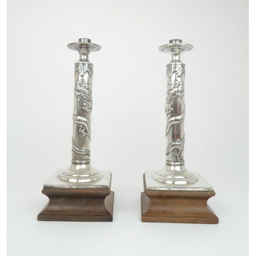 307 - A PAIR OF CHINESE SILVER CANDLESTICK LAMPScast with sinuous dragons, beneath acanthus leaf and above... 