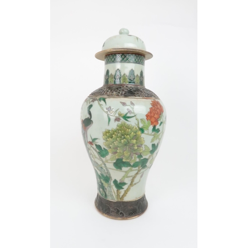 310 - A CHINESE FAMILLE VERTE BALUSTER VASE AND A DOMED COVERpainted with a peacock and foliage within bro... 