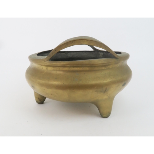 315 - A CHINESE BRONZE TRIPOD CENSERwith raised loop handles and dragon seal mark, 19cm high and 28cm diam... 