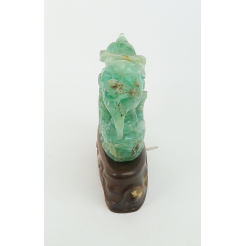 321 - A CHINESE GREEN FLUORSPAR LAMP CARVINGcarved as a dragon boat, seated on a carved hardwood base, 24c... 