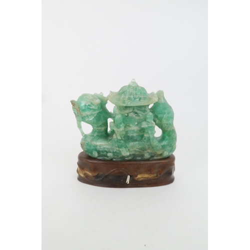 321 - A CHINESE GREEN FLUORSPAR LAMP CARVINGcarved as a dragon boat, seated on a carved hardwood base, 24c... 