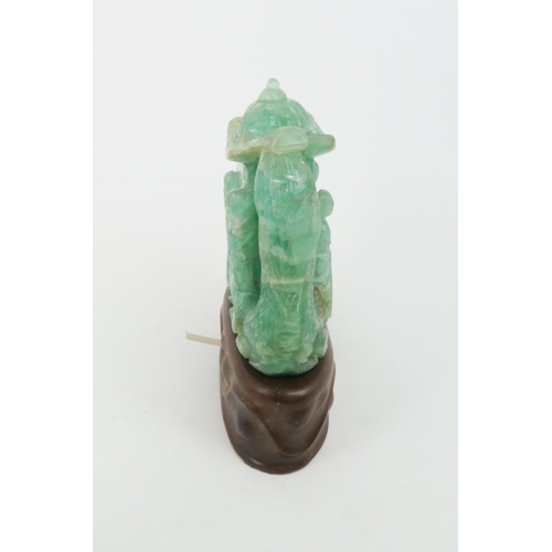 321 - A CHINESE GREEN FLUORSPAR LAMP CARVINGcarved as a dragon boat, seated on a carved hardwood base, 24c... 