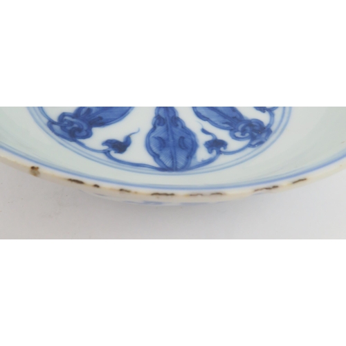 323 - A CHINESE BLUE AND WHITE DISHpainted with precious objects, within a foliate band, 27.5cm diameter, ... 