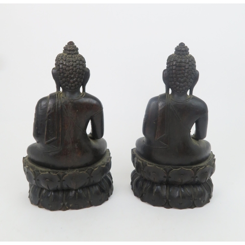 325 - A PAIR OF ASIAN HARDWOOD CARVINGS OF BUDDHAeach seated on a lotus base, 31cm high... 