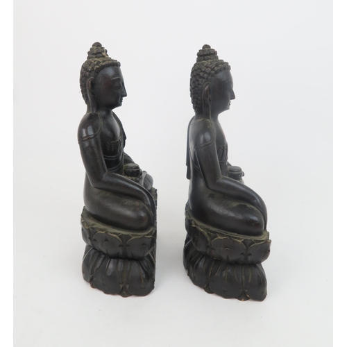 325 - A PAIR OF ASIAN HARDWOOD CARVINGS OF BUDDHAeach seated on a lotus base, 31cm high... 