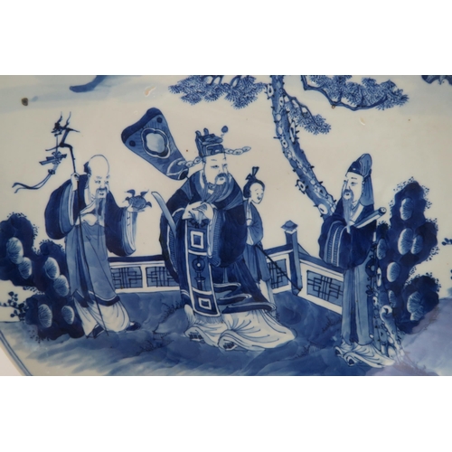 339 - A CHINESE BLUE AND WHITE DISHpainted with a mandarin, sage and officials in a garden and beneath a p... 