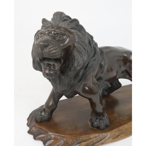 348 - *WITHDRAWN* A JAPANESE BRONZE MODEL OF A LIONnaturalistically modelled, on a carved wooden base, sig... 