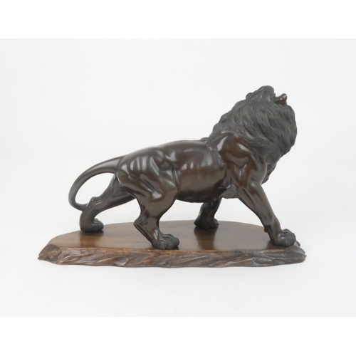 348 - *WITHDRAWN* A JAPANESE BRONZE MODEL OF A LIONnaturalistically modelled, on a carved wooden base, sig... 