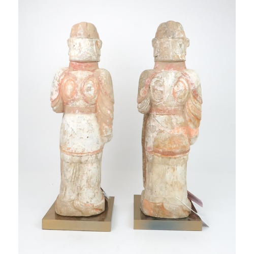 349 - A PAIR OF PAINTED RED POTTERY FIGURES OF SOLDIERSmodelled standing to attention with fierce expressi... 