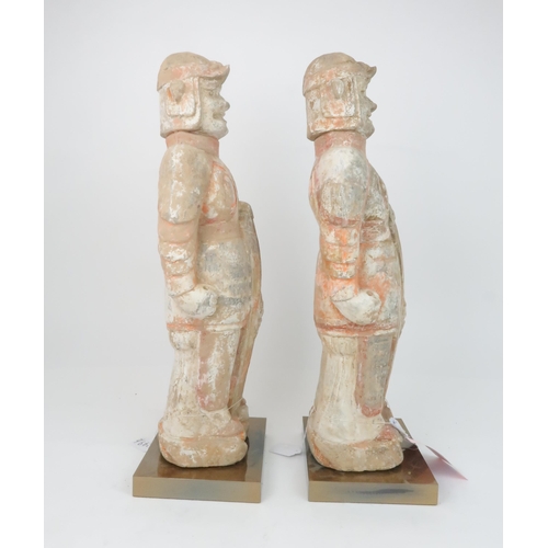 349 - A PAIR OF PAINTED RED POTTERY FIGURES OF SOLDIERSmodelled standing to attention with fierce expressi... 