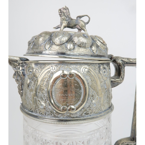 408 - A VICTORIAN SILVER PLATED AND CUT GLASS CLARET JUGthe hinged cover with embossed decoration of fruit... 