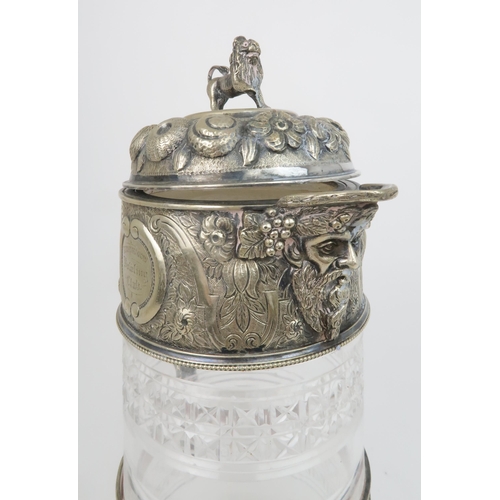 408 - A VICTORIAN SILVER PLATED AND CUT GLASS CLARET JUGthe hinged cover with embossed decoration of fruit... 