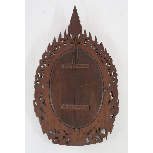 23 - A 20th century eastern oval wall mirror extensively carved throughout, 89cm high x 51cm wide...