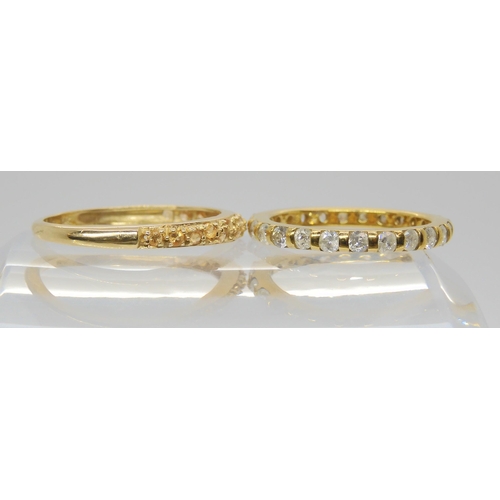 691 - A 14k gold full diamond eternity ring, size M, together with a champagne colour gem set band ring, s... 