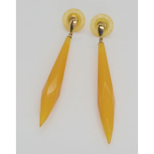 704 - A pair of amber coloured drop earrings, with yellow metal mounts, weight 4gms