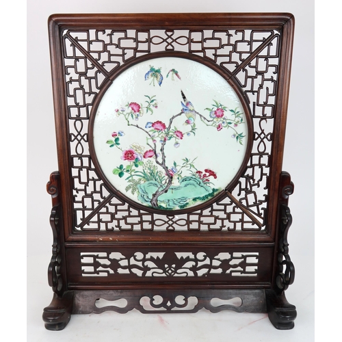 310A - A CHINESE FAMILLE ROSE TILE TABLE SCREENpainted with a bird amongst flowering branches and above roc... 