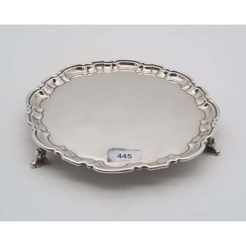 445 - An Elizabeth II silver waiter, with a chippendale style pie crust rim, on three hoof and shell feet,... 