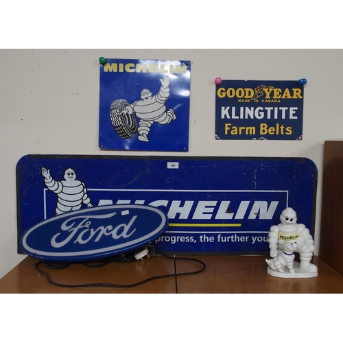 144 - AUTOMOBILIA A cast iron advertising Michelin figure, two Michelin advertising signs, a Goodyear adve... 