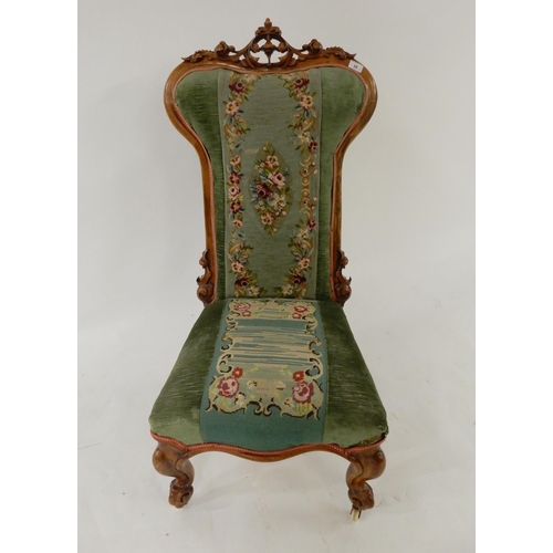 35 - A Victorian walnut framed Prie Dieu chair with floral tapestry upholstery on cabriole supports
