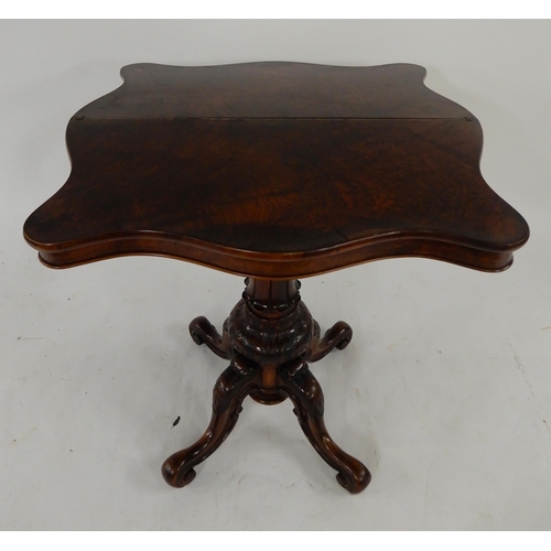 65 - A Victorian walnut serpentine front fold over tea table on baluster quadrupedal base