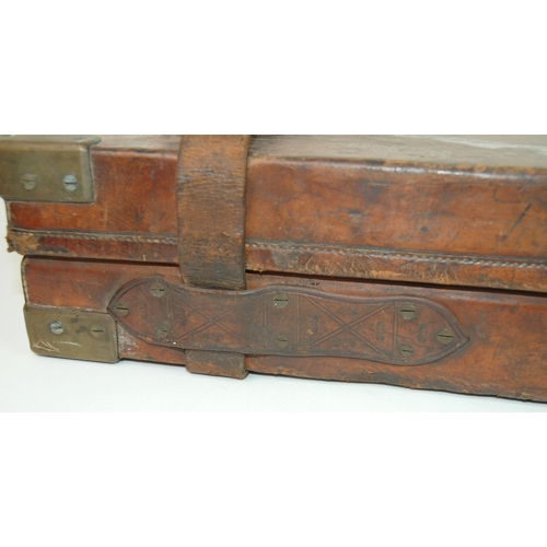 321 - A brown leather and brass bound shotgun case