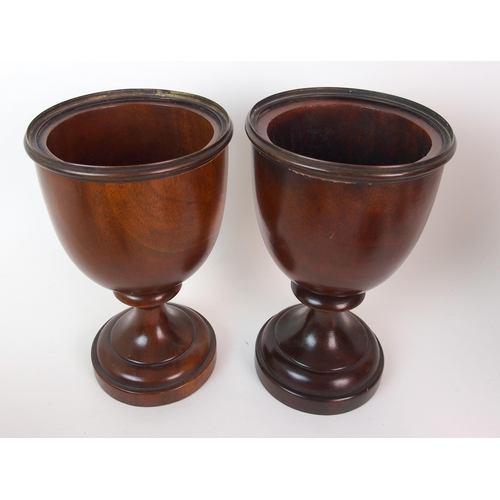 404 - A pair of fluted mahogany urns and covers