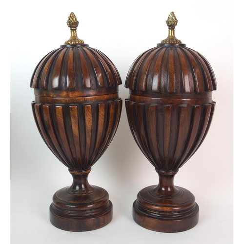 404 - A pair of fluted mahogany urns and covers