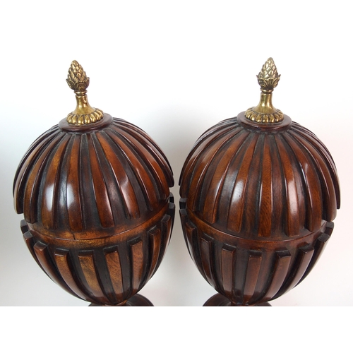 404 - A pair of fluted mahogany urns and covers