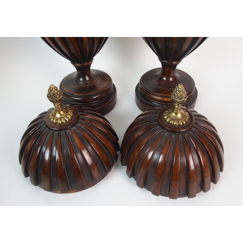 404 - A pair of fluted mahogany urns and covers