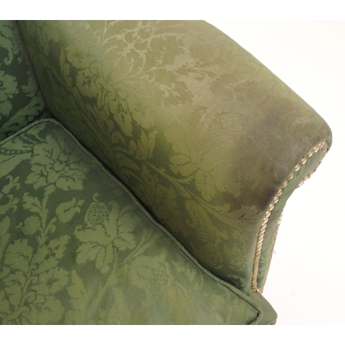 766 - A George III upholstered and brass studded wing armchair