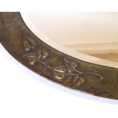 371 - An Arts and Crafts oxidised copper oval wall mirror