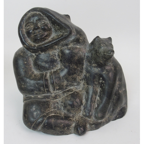 17 - An Inuit hardstone carving on a man seated with his dog