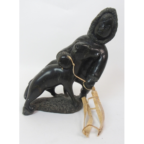 17 - An Inuit hardstone carving on a man seated with his dog