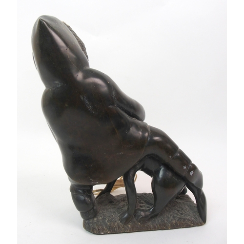 17 - An Inuit hardstone carving on a man seated with his dog