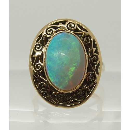 706 - An opal ring with a pierced scrolled yellow metal mount