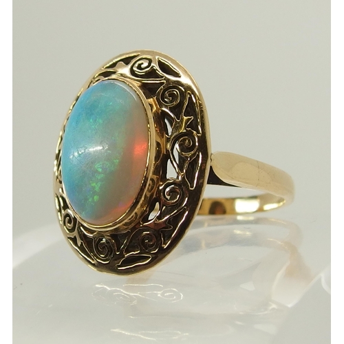 706 - An opal ring with a pierced scrolled yellow metal mount