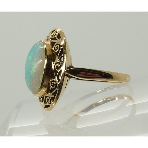 706 - An opal ring with a pierced scrolled yellow metal mount