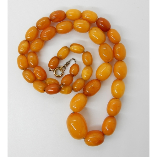 652 - A STRING OF AMBER COLOURED BEADS