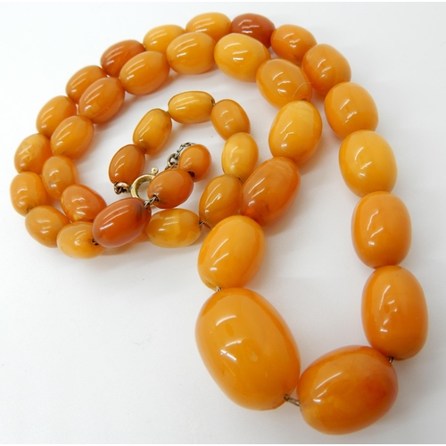 652 - A STRING OF AMBER COLOURED BEADS