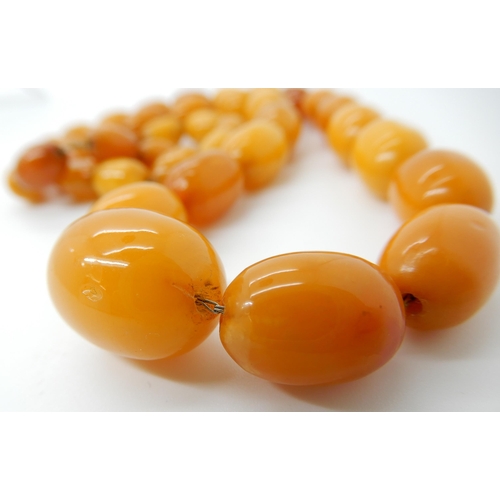 652 - A STRING OF AMBER COLOURED BEADS