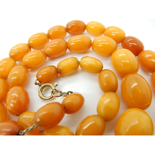 652 - A STRING OF AMBER COLOURED BEADS