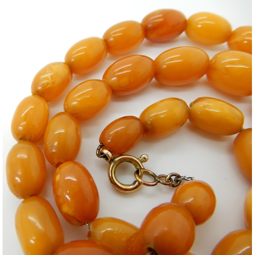 652 - A STRING OF AMBER COLOURED BEADS