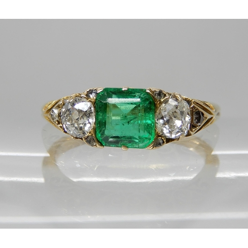 683 - AN EMERALD AND DIAMOND THREE STONE RING