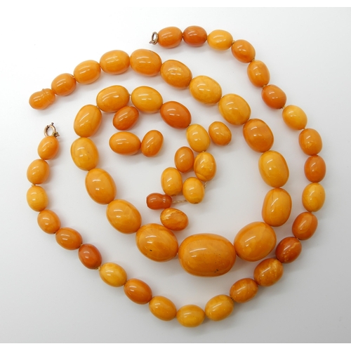 684 - TWO STRINGS OF AMBER COLOURED BEADS